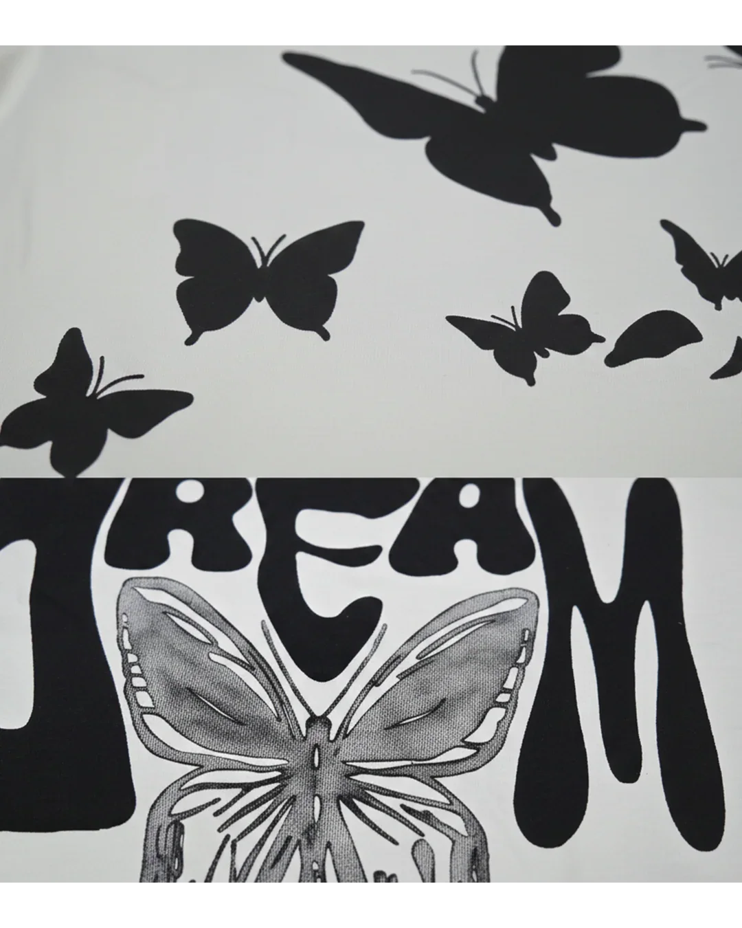 Close-up of white streetwear fabric with black butterfly prints and bold 'DREAM' lettering.