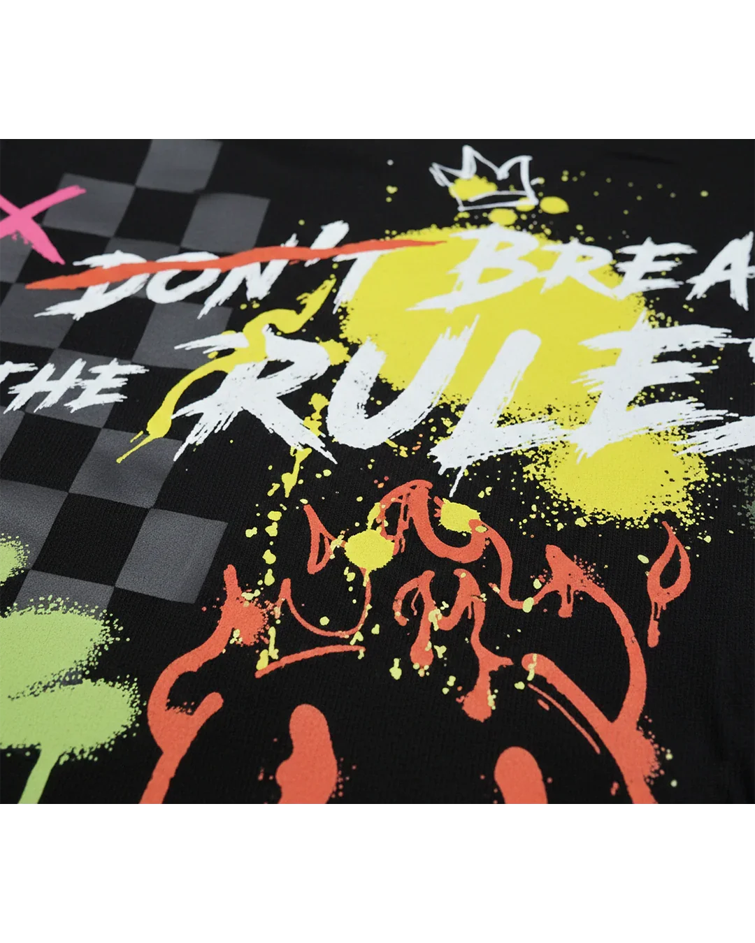 Close-up of black streetwear shirt with graffiti paint splatters, bold text, and checker pattern