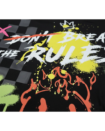 Close-up of black streetwear shirt with graffiti paint splatters, bold text, and checker pattern